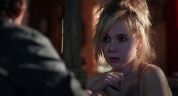 Movie still from “Killer Joe” (2011), directed by William Friedkin – A young woman looking into the camera with a serious look on her face; Close Up shot, Over the shoulder angle