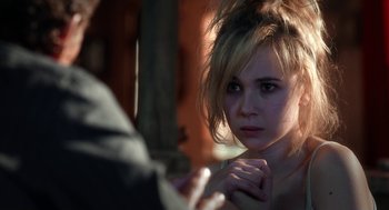 Movie still from “Killer Joe” (2011), directed by William Friedkin – A young woman looking into a mirror with a hand on her chin; Close Up shot, Over the shoulder angle