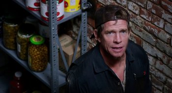 Movie still from “Killer Joe” (2011), directed by William Friedkin – A man wearing a hat standing in front of a shelf; Close Up shot, High angle
