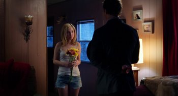 Movie still from “Killer Joe” (2011), directed by William Friedkin – A woman holding a bouquet of flowers in front of a man; Medium shot, Over the shoulder angle
