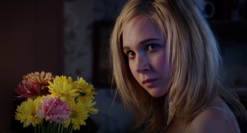 Movie still from “Killer Joe” (2011), directed by William Friedkin – A woman with blonde hair holding a vase of flowers; Close Up shot, Over the shoulder angle