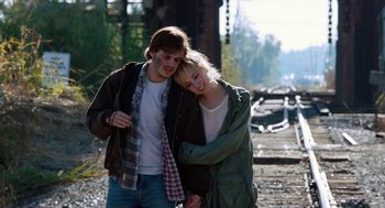 Movie still from “Killer Joe” (2011), directed by William Friedkin – A man and a woman walking on a train track; Medium shot, High angle
