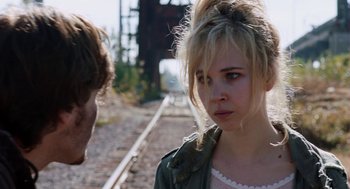 Movie still from “Killer Joe” (2011), directed by William Friedkin – A young woman standing next to a young man on train tracks; Close Up shot, Over the shoulder angle