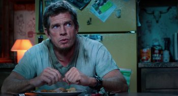 Movie still from “Killer Joe” (2011), directed by William Friedkin – A man sitting at a table with a plate of food in front of him; Close Up shot, Over the shoulder angle
