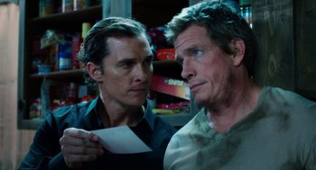 Movie still from “Killer Joe” (2011), directed by William Friedkin – Two men looking at each other while holding a piece of paper in their hands; Close Up shot, Over the shoulder angle