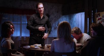 Movie still from “Killer Joe” (2011), directed by William Friedkin – A group of people sitting around a table; Medium shot, Over the shoulder angle
