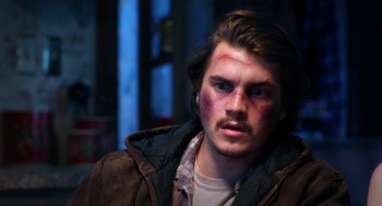 Movie still from “Killer Joe” (2011), directed by William Friedkin – A young man with bruises on his face; Close Up shot, Over the shoulder angle