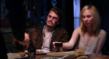 Movie still from “Killer Joe” (2011), directed by William Friedkin – A man and a woman sitting at a dinner table; Medium shot, Over the shoulder angle