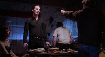 Movie still from “Killer Joe” (2011), directed by William Friedkin – A group of people standing around a table; Medium shot, Over the shoulder angle