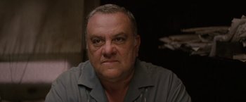 Movie still from “Killing Them Softly” (2012), directed by Andrew Dominik – An older man with gray hair is looking at the camera; Close Up shot, Low angle