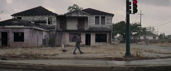 Movie still from “Killing Them Softly” (2012), directed by Andrew Dominik – A man walking a dog down a street; Extreme Wide shot, Low angle