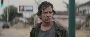 Movie still from “Killing Them Softly” (2012), directed by Andrew Dominik – A person wearing a jacket; Close Up shot, Over the shoulder angle