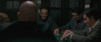 Movie still from “Killing Them Softly” (2012), directed by Andrew Dominik – A group of people sitting at a table playing cards; Medium shot, Over the shoulder angle
