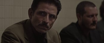 Movie still from “Killing Them Softly” (2012), directed by Andrew Dominik – A person wearing a suit and tie; Close Up shot, Over the shoulder angle