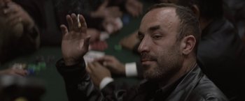 Movie still from “Killing Them Softly” (2012), directed by Andrew Dominik – A person holding a cigarette; Close Up shot, Over the shoulder angle