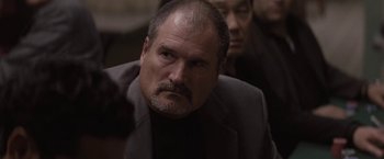 Movie still from “Killing Them Softly” (2012), directed by Andrew Dominik – A person wearing a suit and tie; Close Up shot, Over the shoulder angle