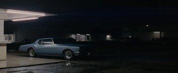 Movie still from “Killing Them Softly” (2012), directed by Andrew Dominik – A car parked in a parking lot at night; Wide shot, Low angle