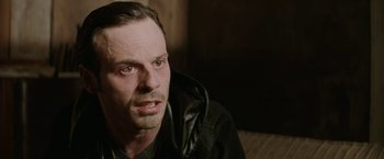 Movie still from “Killing Them Softly” (2012), directed by Andrew Dominik – A person wearing a black jacket; Close Up shot, Over the shoulder angle