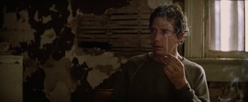 Movie still from “Killing Them Softly” (2012), directed by Andrew Dominik – A man is crying while holding a cigarette in his hand; Close Up shot, Over the shoulder angle