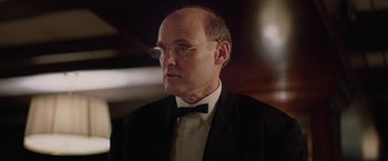 Movie still from “Killing Them Softly” (2012), directed by Andrew Dominik – A man in a suit and bow tie wearing glasses; Close Up shot, Low angle