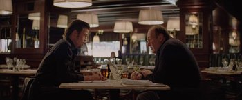 Movie still from “Killing Them Softly” (2012), directed by Andrew Dominik – Two men are sitting at a table in a restaurant; Medium shot, Over the shoulder angle