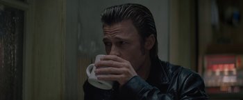 Movie still from “Killing Them Softly” (2012), directed by Andrew Dominik – A man drinking a cup of coffee while wearing a leather jacket; Close Up shot, Low angle