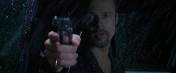 Movie still from “Killing Them Softly” (2012), directed by Andrew Dominik – A person holding a gun in a car; Close Up shot, Over the shoulder angle
