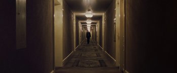 Movie still from “Killing Them Softly” (2012), directed by Andrew Dominik – A person is walking down a hallway in a building; Extreme Wide shot, High angle