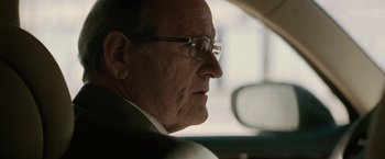 Movie still from “Killing Them Softly” (2012), directed by Andrew Dominik – An older man wearing glasses sitting in a car; Close Up shot, Low angle