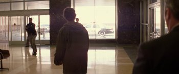 Movie still from “Killing Them Softly” (2012), directed by Andrew Dominik – A woman standing in front of an open window; Wide shot, Over the shoulder angle