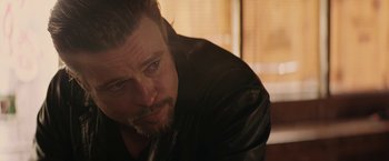 Movie still from “Killing Them Softly” (2012), directed by Andrew Dominik – A person wearing a leather jacket; Close Up shot, Over the shoulder angle