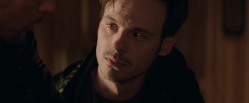 Movie still from “Killing Them Softly” (2012), directed by Andrew Dominik – A person wearing a jacket; Close Up shot, Over the shoulder angle