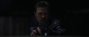 Movie still from “Killing Them Softly” (2012), directed by Andrew Dominik – A man in a leather jacket is holding a camera; Close Up shot, Low angle