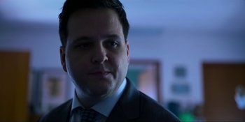 Movie still from “Kimi” (2022), directed by Steven Soderbergh – A person wearing a suit and tie; Close Up shot, Low angle