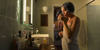 Movie still from “Kimi” (2022), directed by Steven Soderbergh – A woman brushing her teeth in a bathroom; Medium shot, High angle