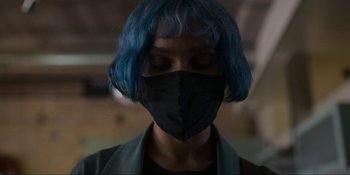 Movie still from “Kimi” (2022), directed by Steven Soderbergh – A woman with blue hair wearing a black mask; Close Up shot, Low angle