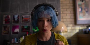 Movie still from “Kimi” (2022), directed by Steven Soderbergh – A person with blue hair wearing headphones and holding something; Close Up shot, Overhead angle
