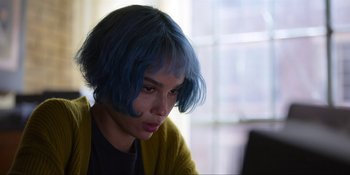 Movie still from “Kimi” (2022), directed by Steven Soderbergh – A woman with blue hair sitting in front of a computer; Close Up shot, High angle