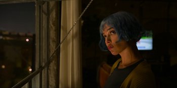 Movie still from “Kimi” (2022), directed by Steven Soderbergh – A woman with blue hair standing next to a window; Close Up shot, Low angle