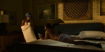 Movie still from “Kimi” (2022), directed by Steven Soderbergh – A man and a woman are lying on a bed; Medium shot, High angle