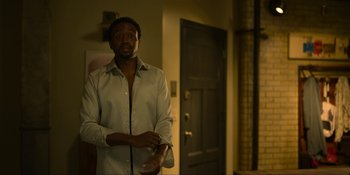 Movie still from “Kimi” (2022), directed by Steven Soderbergh – A man standing in front of an open door; Medium shot, Over the shoulder angle