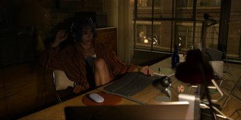 Movie still from “Kimi” (2022), directed by Steven Soderbergh – A person sitting at a table with a laptop; Medium shot, High angle