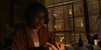 Movie still from “Kimi” (2022), directed by Steven Soderbergh – A woman sitting at a table in front of a window; Medium shot, High angle