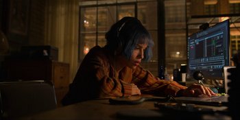 Movie still from “Kimi” (2022), directed by Steven Soderbergh – A person with headphones sitting in front of a computer; Medium shot, High angle