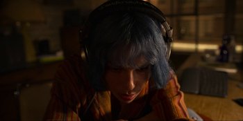 Movie still from “Kimi” (2022), directed by Steven Soderbergh – A woman with blue hair wearing headphones looking down; Close Up shot, Overhead angle