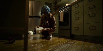 Movie still from “Kimi” (2022), directed by Steven Soderbergh – A person sitting on the floor in a kitchen; Wide shot, High angle