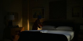 Movie still from “Kimi” (2022), directed by Steven Soderbergh – A person in a room with a lamp on; Wide shot, High angle
