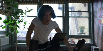 Movie still from “Kimi” (2022), directed by Steven Soderbergh – A woman with blue hair is looking at a tablet computer; Medium shot, Low angle