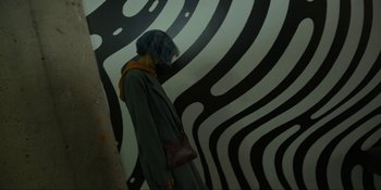 Movie still from “Kimi” (2022), directed by Steven Soderbergh – A woman standing in front of a wall with a zebra pattern; Wide shot, Overhead angle