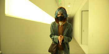 Movie still from “Kimi” (2022), directed by Steven Soderbergh – A person wearing a face mask in a hallway; Medium shot, High angle